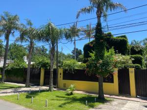 a yellow fence with palm trees in front of it at Felicidades in Rosario