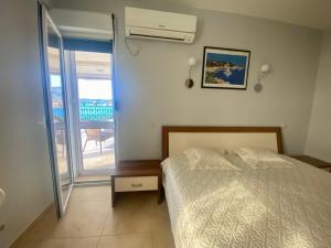 a bedroom with a bed and a view of a balcony at Villa Maja in Sutomore