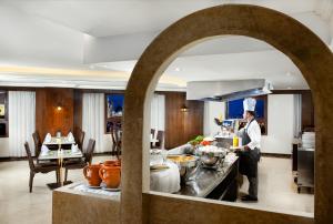 a chef standing in a kitchen in a restaurant at Millennium Taiba Hotel in Medina