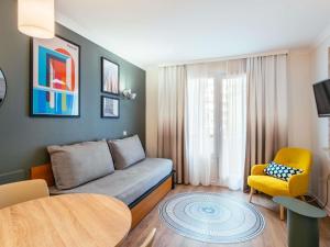 a living room with a couch and a table at Aparthotel Adagio La Défense Le Parc in Courbevoie +37 photos