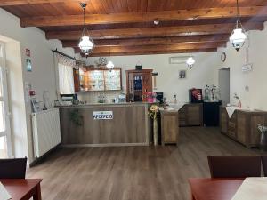 a restaurant with a counter in a room with wooden ceilings at Anna Panzió in Dunavarsány