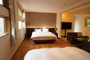 a bedroom with a bed and a couch and a television at 小宿 和Nagomi in Kobe