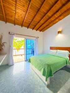 a bedroom with a green bed and a large window at Hotel Costa Linda in Tolú +168 photos