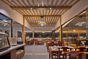 a restaurant with wooden ceilings and tables and chairs at Fenghuang Story Hotel in Fenghuang County