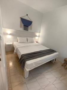 a bedroom with a large bed with a blue curtain at Krystalia's Apartment in Plaka Milou