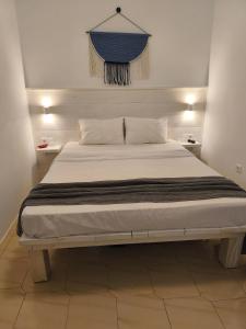 a bedroom with a large bed with white sheets at Krystalia's Apartment in Plaka Milou
