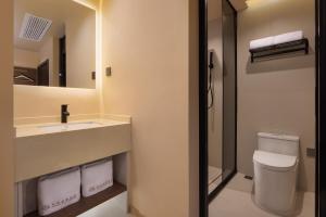 a bathroom with a toilet and a sink and a mirror at Fenghuang Story Hotel in Fenghuang County +42 photos
