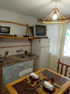 a kitchen with a table and a sink and a refrigerator at Aldea Grampas in Embalse