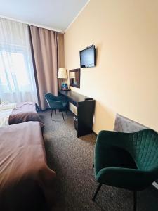 a hotel room with a bed and a desk and a chair at Rezydencja Rosato in Mirkow