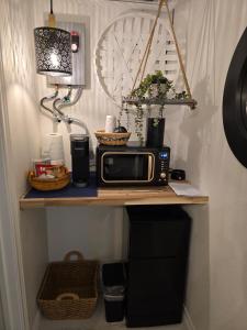 a table with a microwave and a lamp on it at Roots Retreat in Seymour