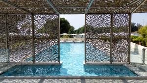 a view of a swimming pool through a metal structure at Hôtel San Lucianu in Moriani Plage