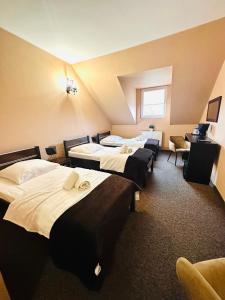 a hotel room with four beds and a window at Rezydencja Rosato in Mirkow