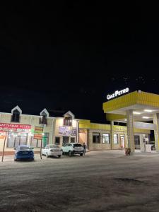 a gas station with cars parked in a parking lot at Гостиница 888 in Zhezdi