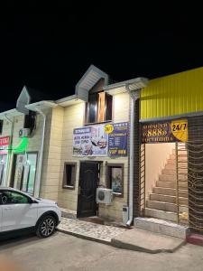 a white car parked in front of a building at Гостиница 888 in Zhezdi