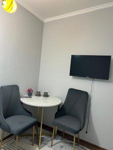 two chairs and a table with a tv on a wall at Гостиница 888 in Zhezdi