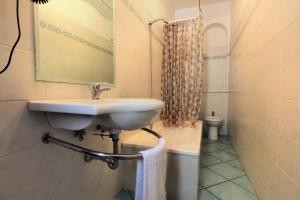 a bathroom with a sink and a mirror at Testa di Monaco Natural Beach in Capo dʼOrlando