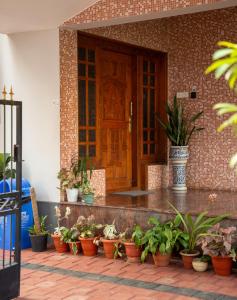 a bunch of potted plants in front of a door at Spacious 3-Bedroom Private Villa in Mangalore - Ideal Getaway for Family and Friends in Mangalore