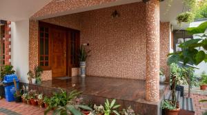 a front porch of a house with potted plants at Spacious 3-Bedroom Private Villa in Mangalore - Ideal Getaway for Family and Friends in Mangalore