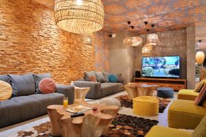 a living room with couches and a tv at Hôtel San Lucianu in Moriani Plage