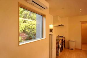 a kitchen with a window and a refrigerator at 小宿 和Nagomi in Kobe