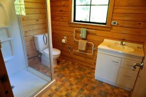 a bathroom with a toilet and a sink and a shower at Mirabell Chalets in Alexandra