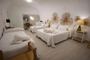 a hotel room with two beds and two mirrors at Alojamientos Cuevas Pinomojon in Cuevas del Campo +63 photos