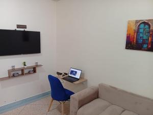 a living room with a couch and a laptop on a table at Tafoukt House in Aourir
