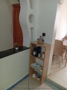 a shelf in a room with a table and a chair at Tafoukt House in Aourir