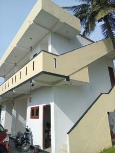 a white house with a staircase on it at Jaya Rest house in Unawatuna