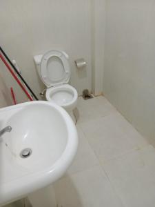 a bathroom with a white sink and a toilet at Jaya Rest house in Unawatuna
