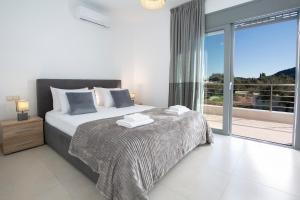a bedroom with a bed and a large window at Valora Villa in Nydri +93 photos
