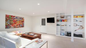 a living room with a white couch and a tv at Villa Willow & Waves in East Hampton