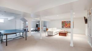 a living room with a table and a couch at Villa Willow & Waves in East Hampton +39 photos