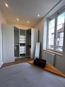 a bedroom with a large bed and a large window at L'arquebuse - Gare Dijon in Dijon