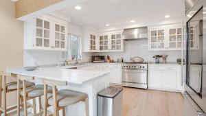 a kitchen with white cabinets and a white counter top at Villa Willow & Waves in East Hampton