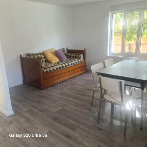 a living room with a couch and a dining room table at Maison typique picarde in Soissons