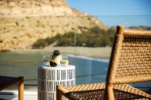 a table with two wine glasses and a view of a mountain at Secret Cave Villa in Matala +38 photos