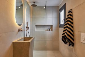 a bathroom with a shower with a sink at Secret Cave Villa in Matala