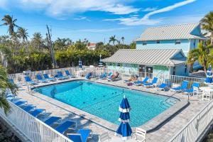 a pool with lounge chairs and umbrellas at Seashells #42 in Ybel