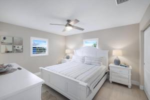 a white bedroom with a bed and a ceiling fan at Seashells #42 in Ybel +18 photos