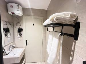 a bathroom with a sink and a shelf with towels at اورا بلس AURA PALACe in Taif +72 photos