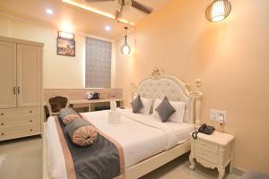 a bedroom with a large white bed with pillows at Shree Ganesha Palace Near Kashi Vishwanath Temple in Varanasi