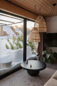 a living room with a table and a large window at Zen Sasino in Sasino