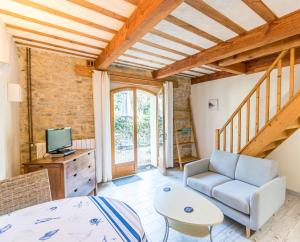 a living room with a couch and a tv at Eloi Merle Gîtes in Olonzac
