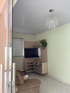 a living room with a couch and a flat screen tv at Raízes do Cerrado in Cavalcante