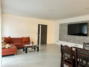 a living room with a red couch and a tv at Tóth Vendégház in Nagykálló
