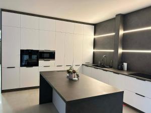 a kitchen with white cabinets and a large island at Tóth Vendégház in Nagykálló