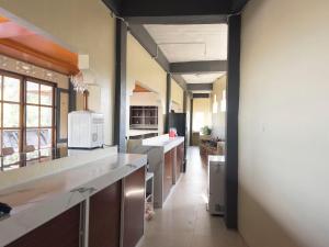 a large kitchen with white counter tops and appliances at Jenny's Villa and Restaurant in Tuktuk Siadong