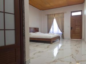 a bedroom with a bed and a window and a door at Jenny's Villa and Restaurant in Tuktuk Siadong