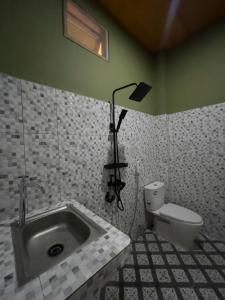 a bathroom with a sink and a toilet at Jenny's Villa and Restaurant in Tuktuk Siadong +22 photos